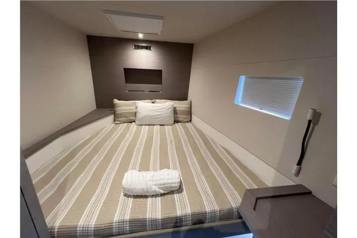 Slide: The Image of 2024 Fountaine Pajot MY6 cabin with striped bedding and modern design. - 20