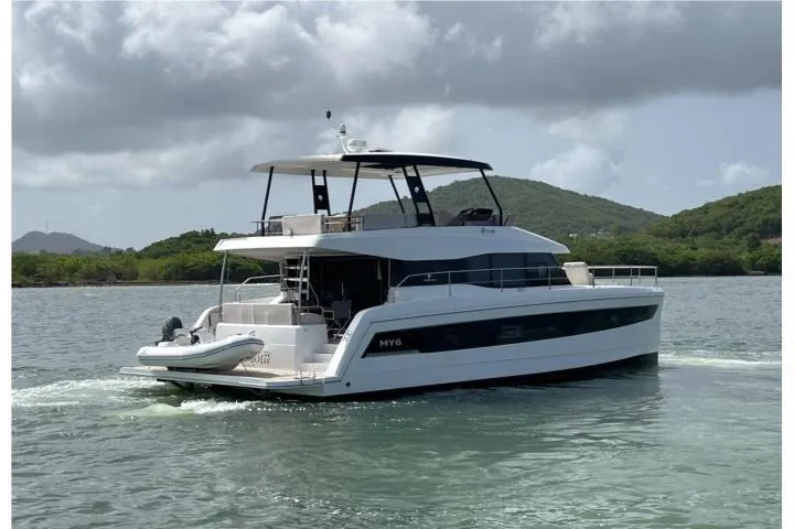 Slide: The Image of 2024 Fountaine Pajot MY6 yacht cruising on a scenic waterway with lush hills in the background. - 3