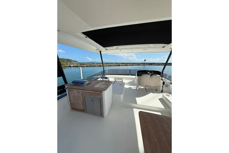 Slide: The Image of 2024 Fountaine Pajot MY6 yacht interior with modern helm and outdoor kitchen. - 4