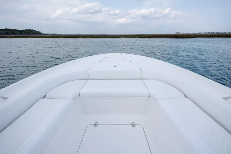 Slide: The Image of Caymas 24 HB 2026 boat on calm water with white deck. - 10