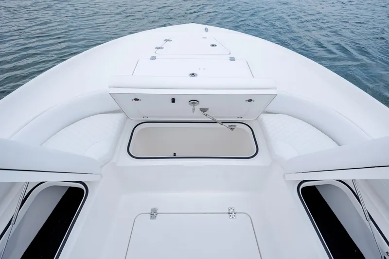 Slide: The Image of Caymas 24 HB 2026 boat with open storage on calm water. - 11