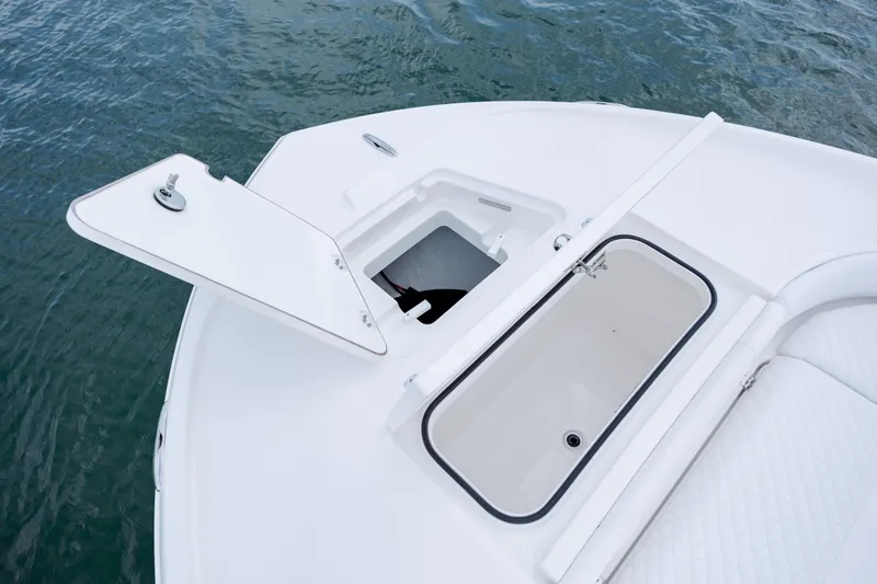 Slide: The Image of Caymas 24 HB 2026 boat with open storage compartment on water. - 12