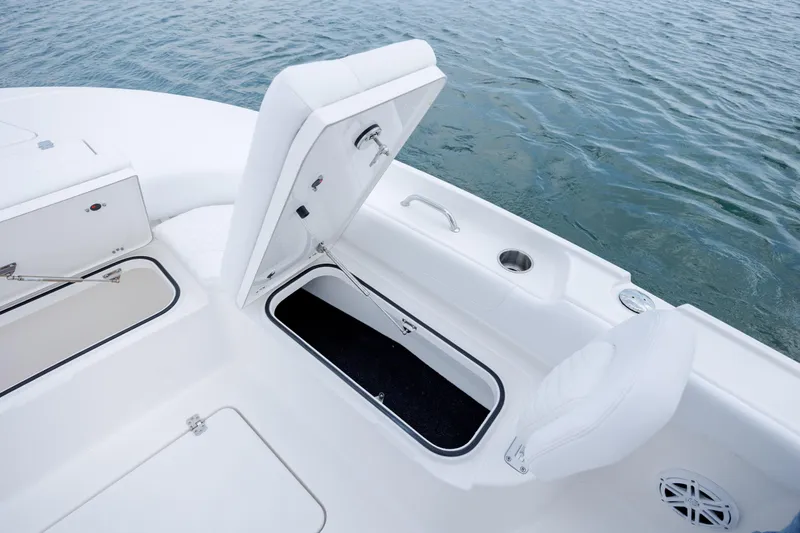 Slide: The Image of Caymas 24 HB 2026 boat with open storage compartment by the water. - 14