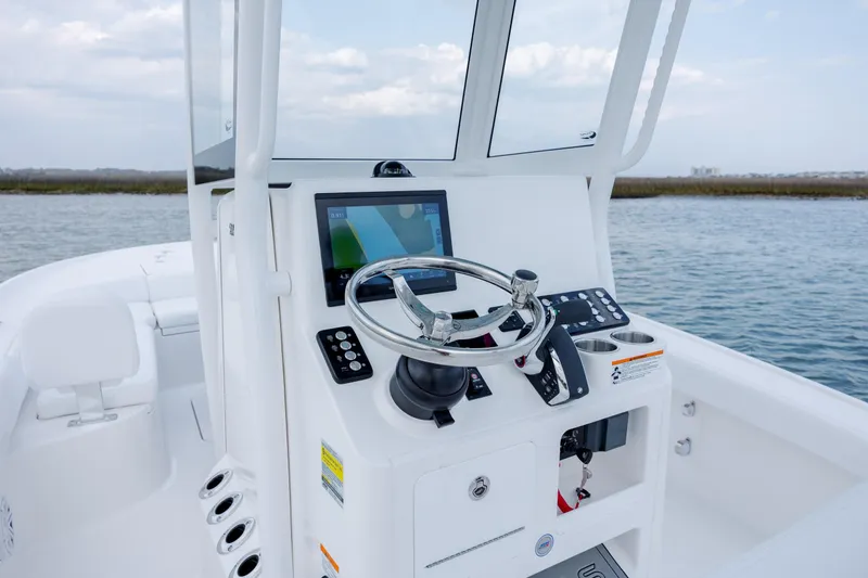 Slide: The Image of 2026 Caymas 24 HB helm console on calm waters. - 22