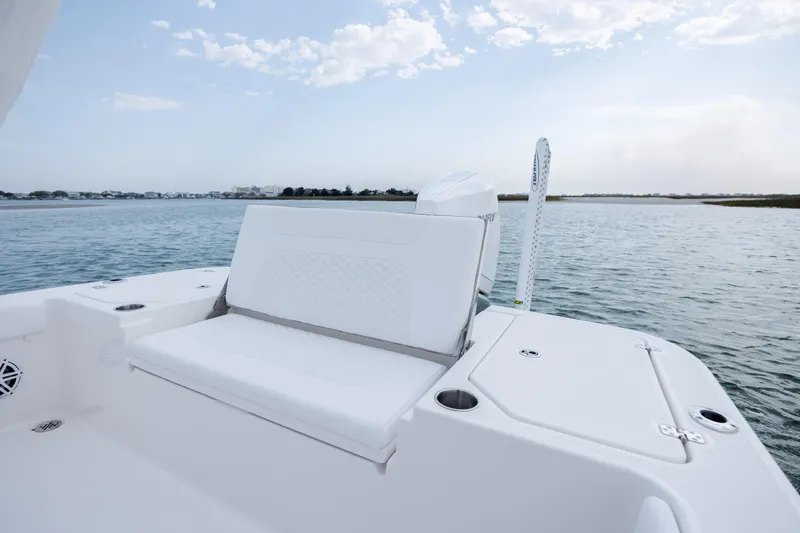 Slide: The Image of Caymas 24 HB 2026 boat on calm water with seating bench. - 31