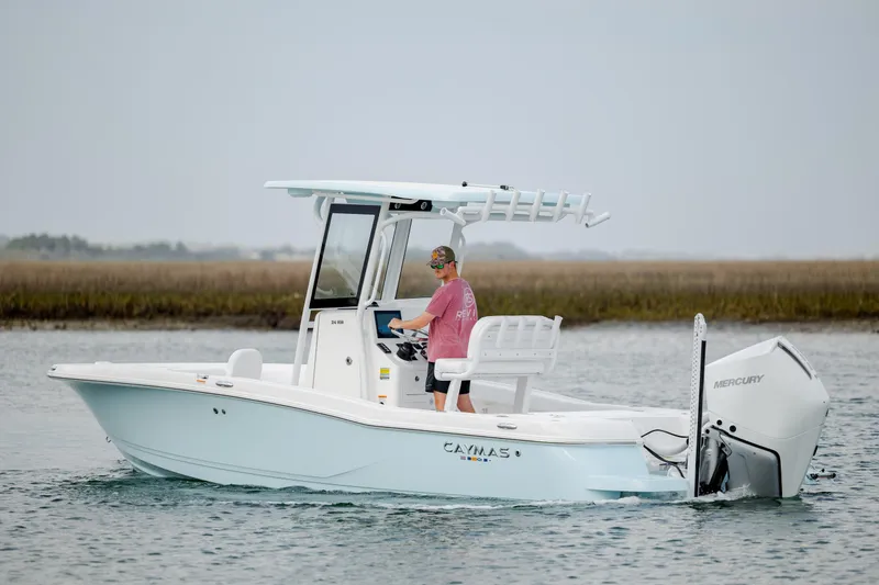 Slide: The Image of 2026 Caymas 24 HB boat cruising on water with Mercury engine. - 5