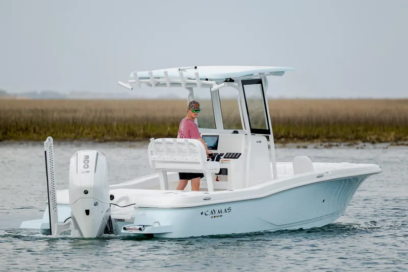 Slide: The Image of 2026 Caymas 24 HB boat cruising on water with a person at the helm. - 7