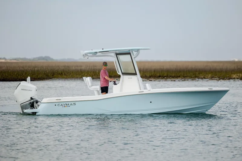 Slide: The Image of 2026 Caymas 24 HB boat on water with Mercury engine, side view. - 9