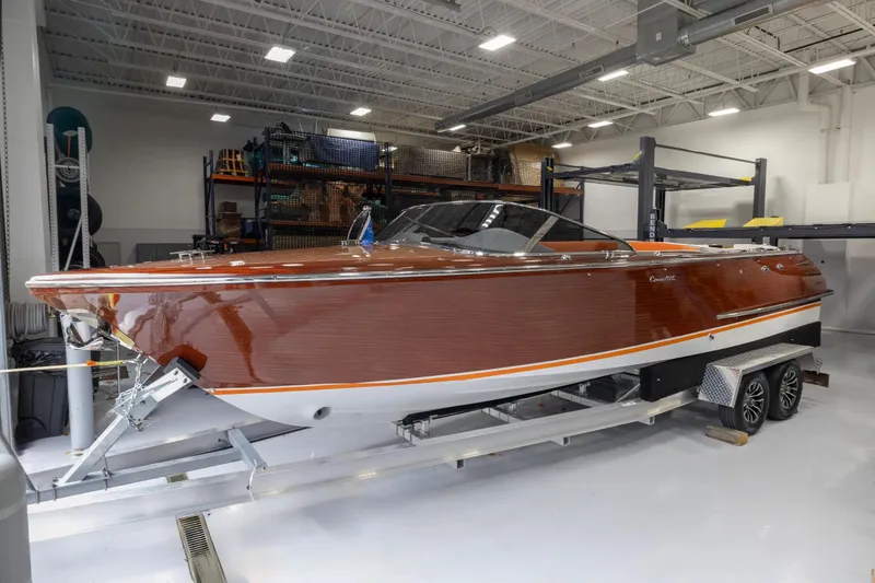 The Image of 2025 Comitti Venezia V28 luxury boat in a modern indoor storage facility. - 1