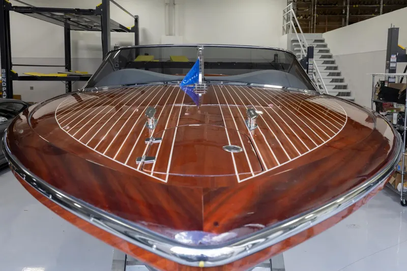 Slide: The Image of 2025 Comitti Venezia V28 luxury boat with polished wooden deck in a showroom. - 12