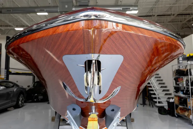 Slide: The Image of 2025 Comitti Venezia V28 boat with polished wood finish in a showroom. - 13