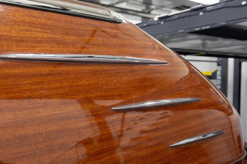 Slide: The Image of Close-up of 2025 Comitti Venezia V28's polished wooden hull with chrome accents. - 15