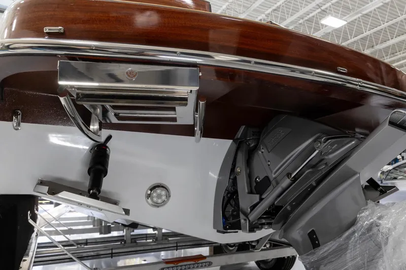 Slide: The Image of 2025 Comitti Venezia V28 boat stern with polished wood finish and modern outboard motor. - 17