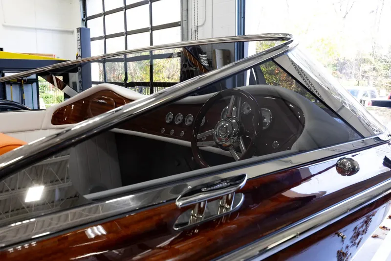 Slide: The Image of 2025 Comitti Venezia V28 luxury boat interior with polished wood and sleek dashboard design. - 20