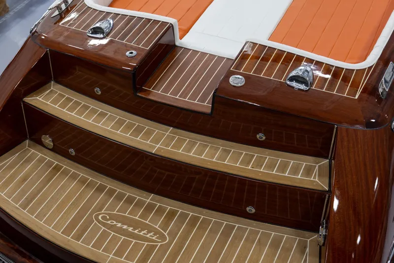 Slide: The Image of 2025 Comitti Venezia V28 boat with elegant wooden deck and orange seating. - 5