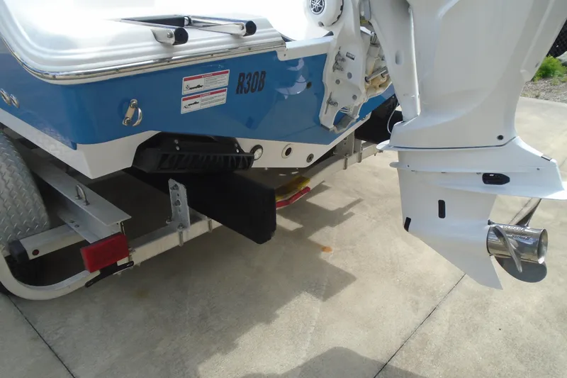 Slide: The Image of 2024 Sportsman Heritage 231 Center Console boat on trailer, showcasing outboard motor and hull details. - 6