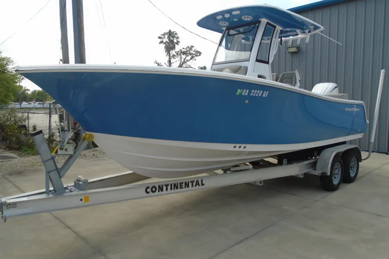 Slide: The Image of 2024 Sportsman Heritage 231 Center Console boat on trailer, blue hull, parked outdoors. - 8