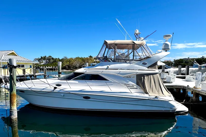The Image of 2001 Sea Ray 400 Sedan Bridge yacht docked at marina under clear blue sky. - 1