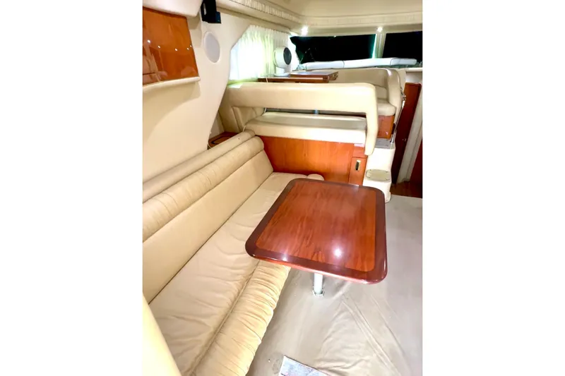Slide: The Image of Luxurious interior of 2001 Sea Ray 400 Sedan Bridge with beige seating and wooden table. - 4