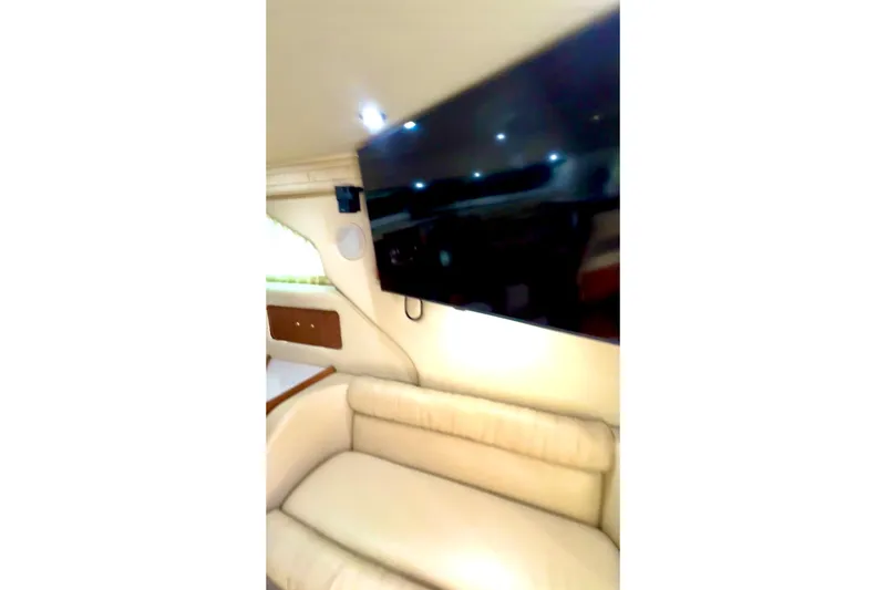 Slide: The Image of Interior of 2001 Sea Ray 400 Sedan Bridge with TV and beige seating. - 5