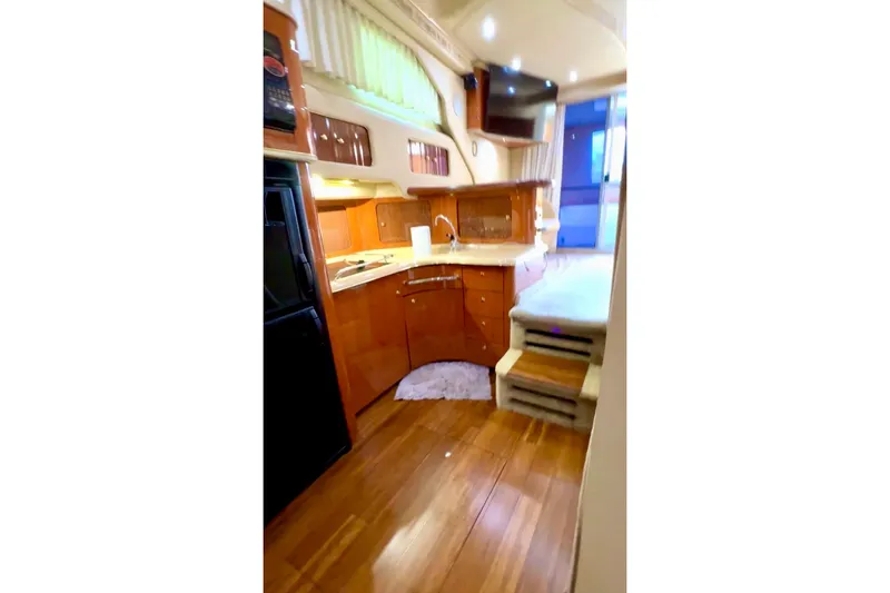 Slide: The Image of Interior of 2001 Sea Ray 400 Sedan Bridge yacht with wooden flooring and modern kitchen. - 7