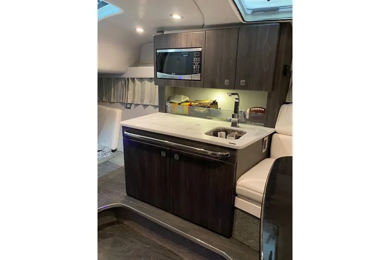 Slide: The Image of 2020 Formula 350 Sun Sport boat interior with kitchenette, microwave, and sink. - 18