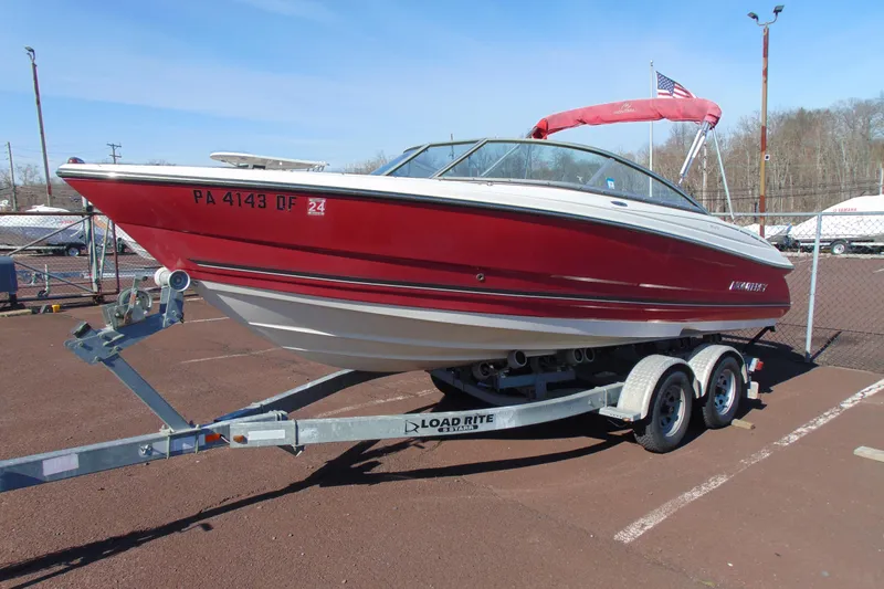 The Image of Red 2009 Monterey 214FS boat on trailer in parking lot. - 1