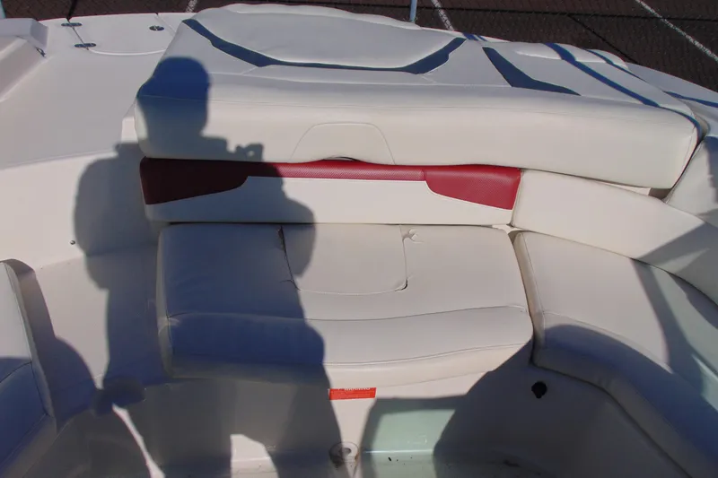 Slide: The Image of 2009 Monterey 214FS boat interior with white and red seating, shadow visible. - 10