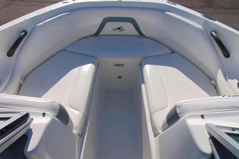 Slide: The Image of 2009 Monterey 214FS boat interior with white cushioned seating and sleek design. - 17