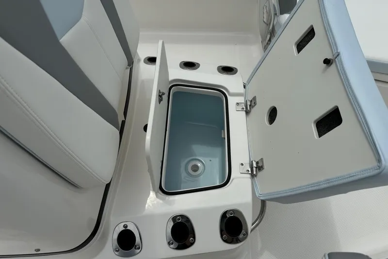 Slide: The Image of Open storage compartment on 2026 Robalo 206 Cayman boat with rod holders. - 19
