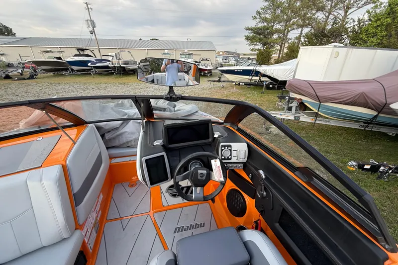 Slide: The Image of 2023 Malibu Wakesetter 23 LSV interior with orange accents and modern dashboard. - 16