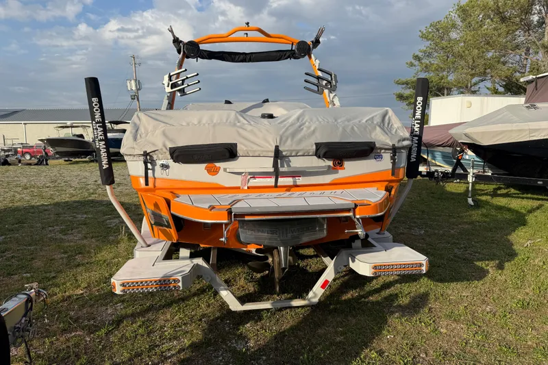 Slide: The Image of 2023 Malibu Wakesetter 23 LSV boat, orange and gray, parked outdoors. - 4