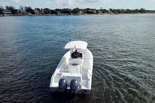 Slide: The Image of 2018 Sea Hunt Gamefish 27 Coffin Box boat on calm water, distant shoreline view. - 3