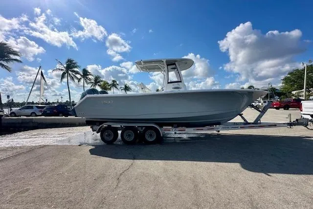 Slide: The Image of 2018 Sea Hunt Gamefish 27 Coffin Box boat on trailer, sunny day, palm trees in background. - 9