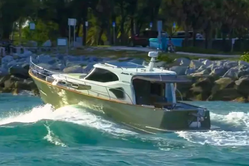 Slide: The Image of 2019 Monachus 45 Issa yacht navigating through waves near rocky shoreline. - 21