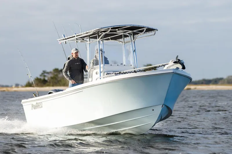 Slide: The Image of Manufacturer Provided Image: 2026 Parker 210 Coastal boat cruising on open water, featuring fishing rods and sleek design. - 2