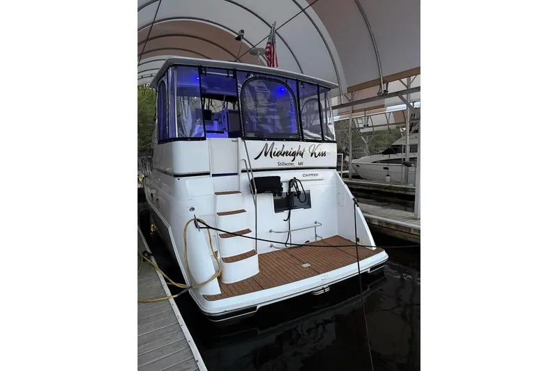 Slide: The Image of 2000 Carver 406 Aft Cabin Motor Yacht docked, featuring elegant design and blue lighting. - 4