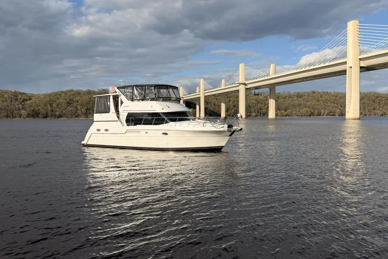 Slide: The Image of 2000 Carver 406 Aft Cabin Motor Yacht on river near modern bridge. - 44