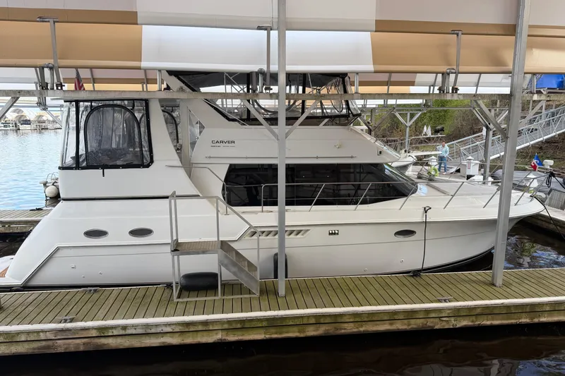 Slide: The Image of 2000 Carver 406 Aft Cabin Motor Yacht docked under a covered marina. - 49