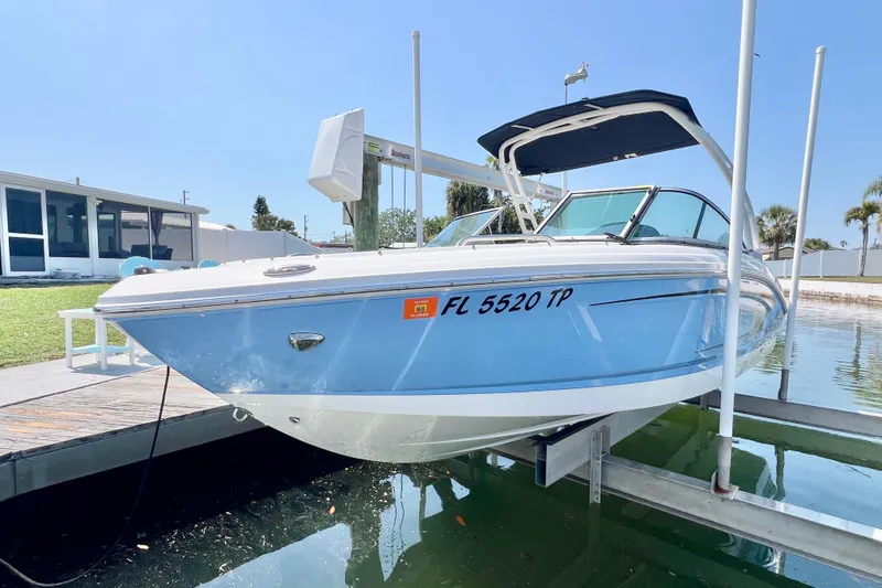 The Image of 2023 Chaparral 21 SSi OB boat docked, featuring sleek blue and white design. - 0