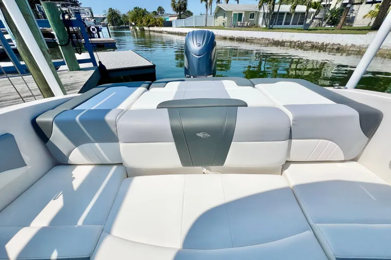 Slide: The Image of 2023 Chaparral 21 SSi OB boat interior with cushioned seating and outboard motor. - 10