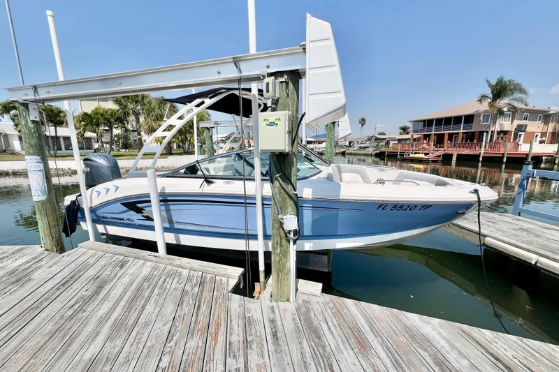 Slide: The Image of 2023 Chaparral 21 SSi OB boat docked at a marina, showcasing sleek design and modern features. - 3