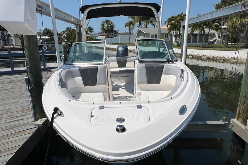 Slide: The Image of 2023 Chaparral 21 SSi OB boat docked, featuring sleek design and spacious seating. - 4