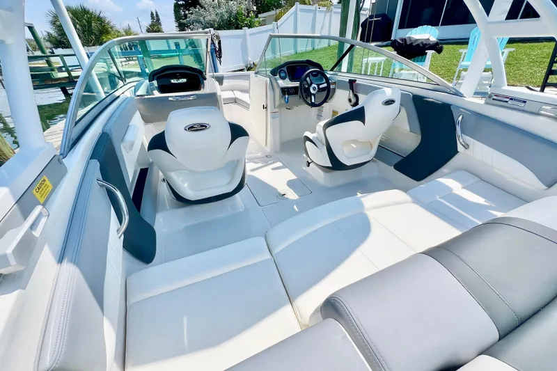 Slide: The Image of 2023 Chaparral 21 SSi OB boat interior with white seating and modern dashboard. - 7