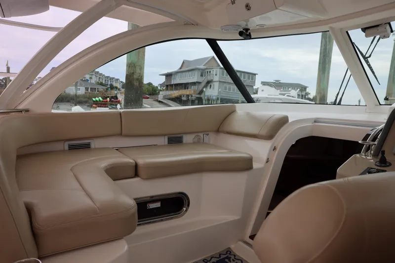 Slide: The Image of 2015 Pursuit OS 385 Offshore boat on stands, viewed from the rear, under a cloudy sky. - 11