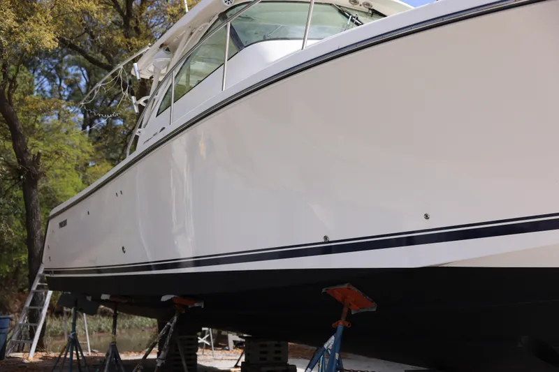 Slide: The Image of 2015 Pursuit OS 385 Offshore boat on stands, side view, outdoors. - 4