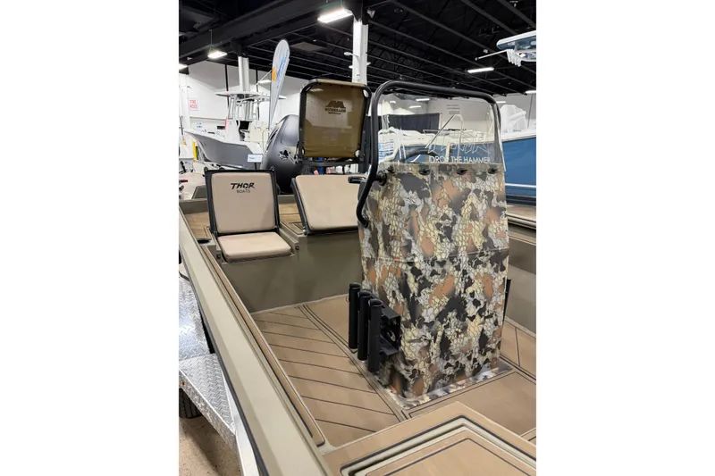 Slide: The Image of 2026 Thor Lake Hammer 1900 boat interior with camouflage console and seating. - 2