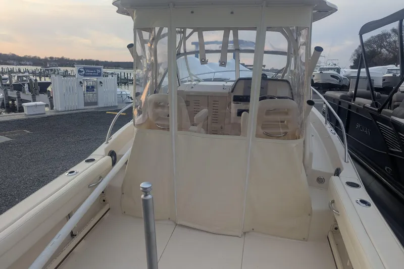 Slide: The Image of 2023 Grady-White Adventure 218 boat docked at marina, featuring enclosed helm area. - 3