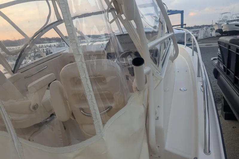 Slide: The Image of 2023 Grady-White Adventure 218 boat with enclosed cockpit, docked at marina. - 5