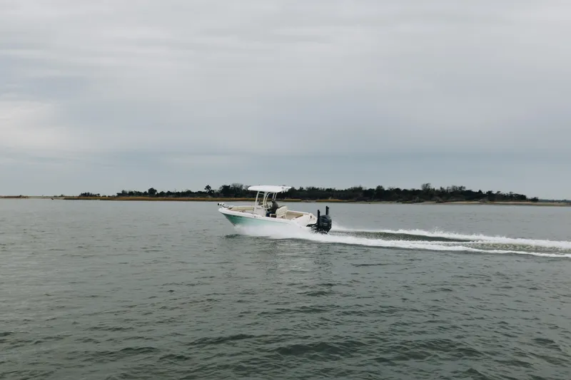 Slide: The Image of 2017 Robalo R222 Center Console boat cruising on open water under cloudy skies. - 2